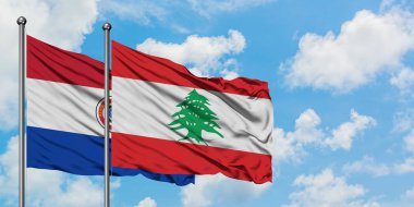 Paraguay ve Lübnan bayrağı birlikte beyaz bulutlu mavi gökyüzüne karşı rüzgarda sallayarak. Diplomasi kavramı, uluslararası ilişkiler.