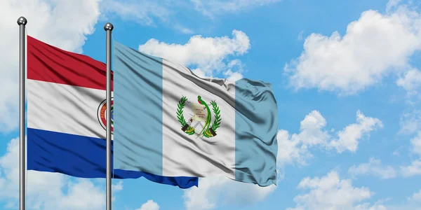 Парагвай и Гватемала вместе машут на ветру белым облачно-голубым небом. Концепция дипломатии, международные отношения . — стоковое фото