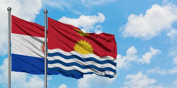 Bandera de Paraguay y Kiribati ondeando en el viento contra el cielo azul nublado blanco juntos. Concepto diplomático, relaciones internacionales . — Foto de Stock