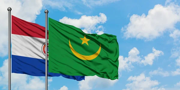 Bandera de Paraguay y Mauritania ondeando en el viento contra el cielo azul nublado blanco juntos. Concepto diplomático, relaciones internacionales . — Foto de Stock