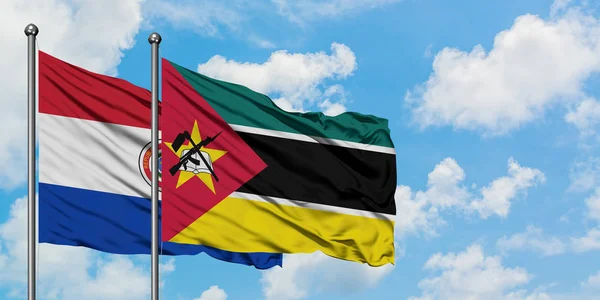 Bandera de Paraguay y Mozambique ondeando en el viento contra el cielo azul nublado blanco juntos. Concepto diplomático, relaciones internacionales . — Foto de Stock