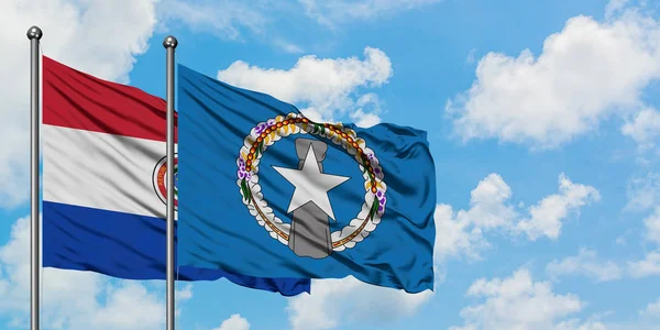 Bandera de Paraguay y las Islas Marianas del Norte ondeando en el viento contra el cielo azul nublado blanco juntos. Concepto diplomático, relaciones internacionales . — Foto de Stock