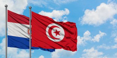 Paraguay ve Tunus bayrağı birlikte beyaz bulutlu mavi gökyüzüne karşı rüzgarsal sallayarak. Diplomasi kavramı, uluslararası ilişkiler.