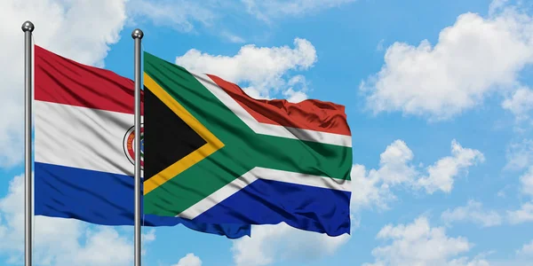Paraguay e Sudafrica sventolano insieme la bandiera contro il bianco cielo azzurro nuvoloso. Concetto di diplomazia, relazioni internazionali . — Foto Stock