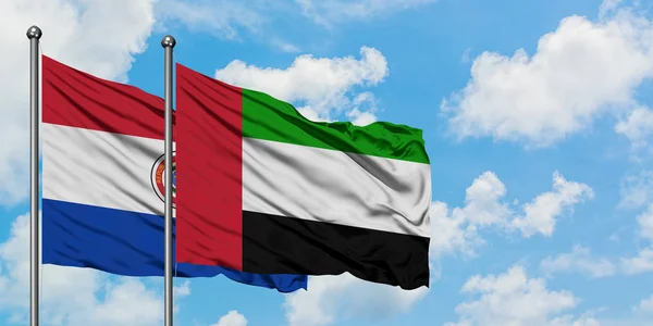 Paraguay ed Emirati Arabi Uniti sventolano insieme contro il bianco cielo azzurro nuvoloso. Concetto di diplomazia, relazioni internazionali . — Foto Stock