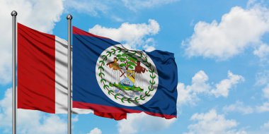 Peru ve Belize bayrağı birlikte beyaz bulutlu mavi gökyüzüne karşı rüzgarda sallayarak. Diplomasi kavramı, uluslararası ilişkiler.