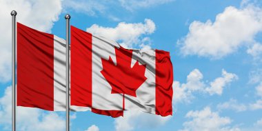 Peru ve Kanada bayrağı birlikte beyaz bulutlu mavi gökyüzüne karşı rüzgarda sallayarak. Diplomasi kavramı, uluslararası ilişkiler.