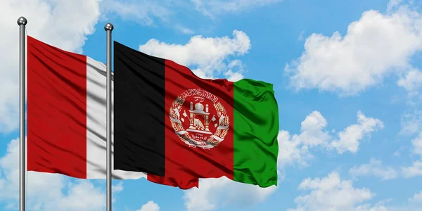 Bandera de Perú y Afganistán ondeando en el viento contra el cielo azul nublado blanco juntos. Concepto diplomático, relaciones internacionales . — Foto de Stock