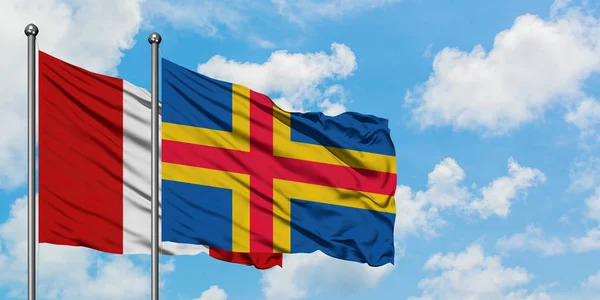 Peru and Aland Islands flag waving in the wind against white cloudy blue sky together. Diplomacy concept, international relations. — Stock Photo, Image