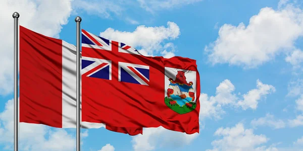 Bandera de Perú y Bermudas ondeando en el viento contra el cielo azul nublado blanco juntos. Concepto diplomático, relaciones internacionales . —  Fotos de Stock