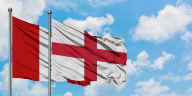 Peru ve İngiltere bayrağı birlikte beyaz bulutlu mavi gökyüzüne karşı rüzgarda sallayarak. Diplomasi kavramı, uluslararası ilişkiler.