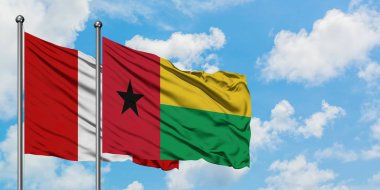 Peru ve Gine Bissau bayrağı birlikte beyaz bulutlu mavi gökyüzüne karşı rüzgarda sallayarak. Diplomasi kavramı, uluslararası ilişkiler.