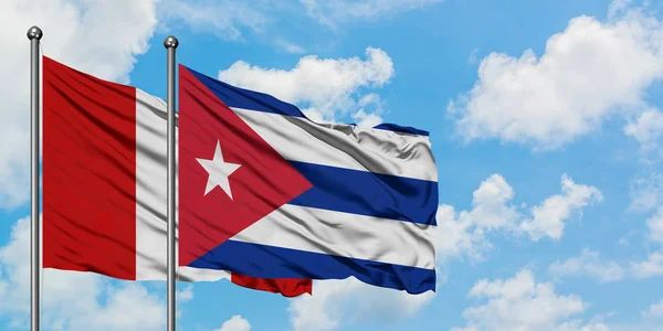 Bandera de Perú y Cuba ondeando en el viento contra el cielo azul nublado blanco juntos. Concepto diplomático, relaciones internacionales . — Foto de Stock