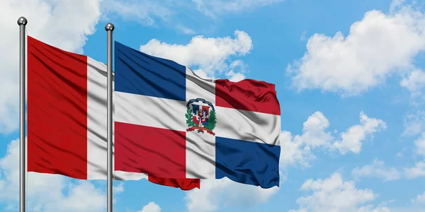 Peru e República Dominicana acenando com o vento contra o céu azul nublado branco juntos. Conceito de diplomacia, relações internacionais . — Fotografia de Stock