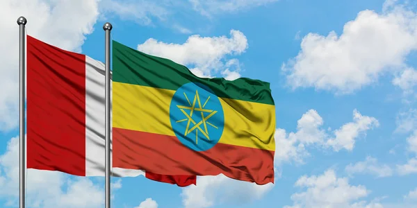 Peru och Etiopien sjunker vifta i vinden mot vit grumlig blå himmel tillsammans. Diplomatisk koncept, internationella relationer. — Stockfoto
