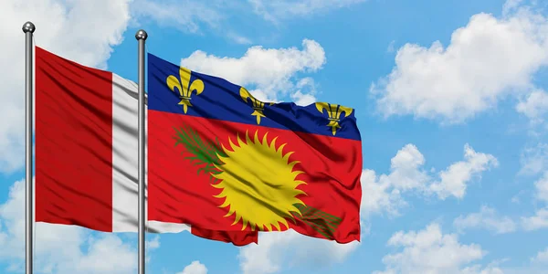 Bandera de Perú y Guadalupe ondeando en el viento contra el cielo azul nublado blanco juntos. Concepto diplomático, relaciones internacionales . — Foto de Stock