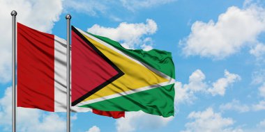 Peru ve Guyana bayrağı birlikte beyaz bulutlu mavi gökyüzüne karşı rüzgarda sallayarak. Diplomasi kavramı, uluslararası ilişkiler.
