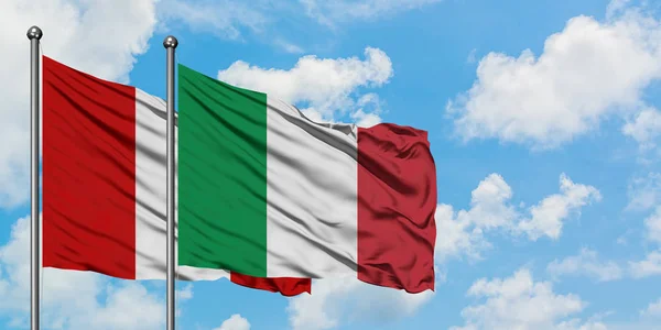 Bandera de Perú e Italia ondeando en el viento contra el cielo azul nublado blanco juntos. Concepto diplomático, relaciones internacionales . — Foto de Stock