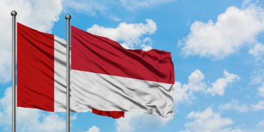 Peru ve Monako bayrağı birlikte beyaz bulutlu mavi gökyüzüne karşı rüzgarda sallayarak. Diplomasi kavramı, uluslararası ilişkiler.