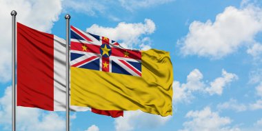 Peru ve Niue bayrağı birlikte beyaz bulutlu mavi gökyüzüne karşı rüzgarda sallayarak. Diplomasi kavramı, uluslararası ilişkiler.