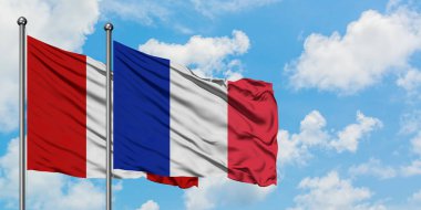 Peru ve Reunion bayrağı birlikte beyaz bulutlu mavi gökyüzüne karşı rüzgarda sallayarak. Diplomasi kavramı, uluslararası ilişkiler.