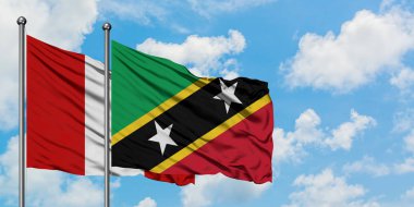 Peru ve Saint Kitts ve Nevis bayrağı birlikte beyaz bulutlu mavi gökyüzüne karşı rüzgarda sallayarak. Diplomasi kavramı, uluslararası ilişkiler.