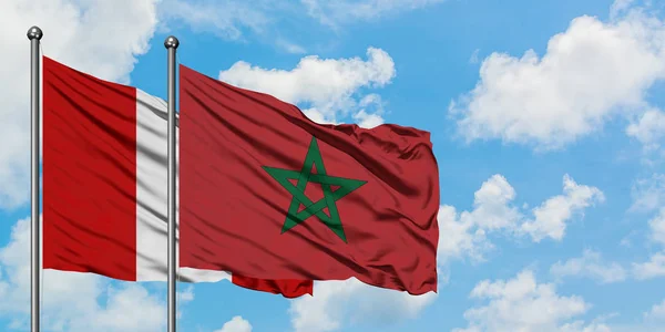 Bandera de Perú y Marruecos ondeando en el viento contra el cielo azul nublado blanco juntos. Concepto diplomático, relaciones internacionales . — Foto de Stock