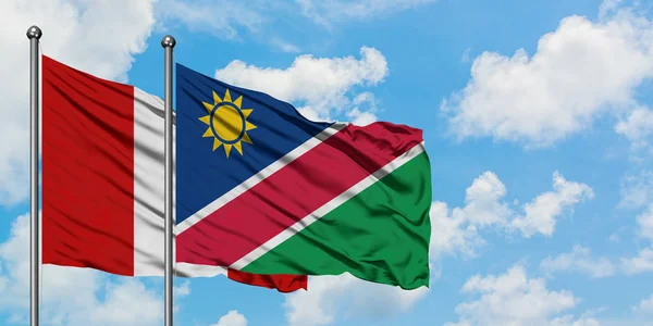 Drapeau du Pérou et de la Namibie agitant dans le vent contre ciel bleu nuageux blanc ensemble. Concept de diplomatie, relations internationales . — Photo