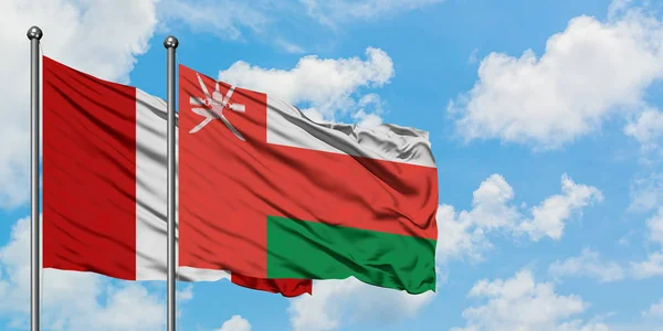 Bandera de Perú y Omán ondeando en el viento contra el cielo azul nublado blanco juntos. Concepto diplomático, relaciones internacionales . — Foto de Stock