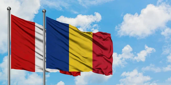 秘鲁和罗马尼亚国旗在风中飘扬，白云蓝天相经。外交概念、国际关系. — 图库照片