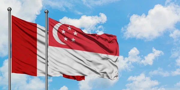 Peruánská a Singapurská vlajka mávali ve větru proti bíle zatažené modré obloze. Diplomacie, mezinárodní vztahy. — Stock fotografie