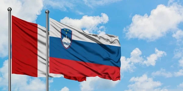Peru and Slovenia flag waving in the wind against white cloudy blue sky together. Diplomacy concept, international relations. — Stock Photo, Image