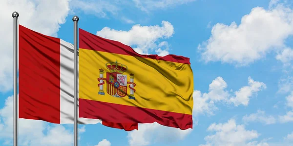 Bandera de Perú y España ondeando en el viento contra el cielo azul nublado blanco juntos. Concepto diplomático, relaciones internacionales . — Foto de Stock