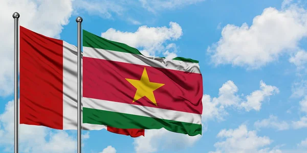 Bandera de Perú y Surinam ondeando en el viento contra el cielo azul nublado blanco juntos. Concepto diplomático, relaciones internacionales . — Foto de Stock