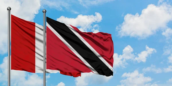 Peru en Trinidad en Tobago vlag zwaaien in de wind tegen witte bewolkte blauwe hemel samen. Diplomatie concept, internationale betrekkingen. — Stockfoto