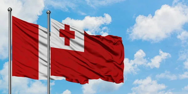 Peru a Tonga praporce ve větru mávali proti bíle zatažené modré obloze. Diplomacie, mezinárodní vztahy. — Stock fotografie