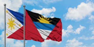 Filipinler ve Antigua ve Barbuda bayrağı birlikte beyaz bulutlu mavi gökyüzüne karşı rüzgarda sallayarak. Diplomasi kavramı, uluslararası ilişkiler.