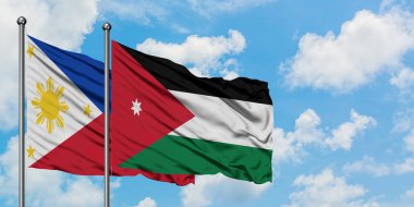 Filipinler ve Ürdün bayrağı birlikte beyaz bulutlu mavi gökyüzüne karşı rüzgarda sallayarak. Diplomasi kavramı, uluslararası ilişkiler.