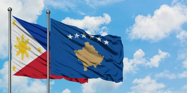 Bandera de Filipinas y Kosovo ondeando en el viento contra el cielo azul nublado blanco juntos. Concepto diplomático, relaciones internacionales . — Foto de Stock