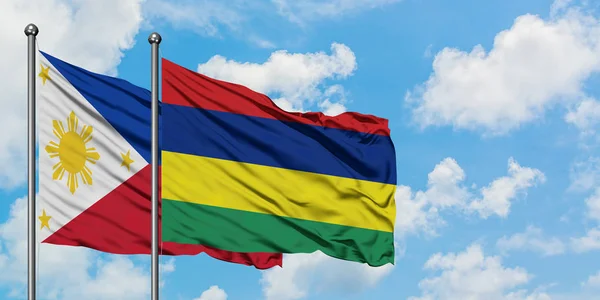 Bandera de Filipinas y Mauricio ondeando en el viento contra el cielo azul nublado blanco juntos. Concepto diplomático, relaciones internacionales . — Foto de Stock