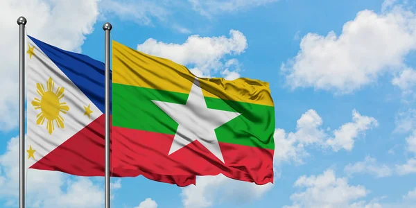 Bandera de Filipinas y Myanmar ondeando en el viento contra el cielo azul nublado blanco juntos. Concepto diplomático, relaciones internacionales . —  Fotos de Stock