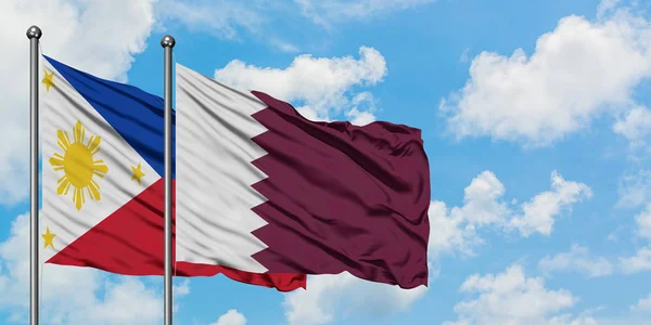 Bandera de Filipinas y Qatar ondeando en el viento contra el cielo azul nublado blanco juntos. Concepto diplomático, relaciones internacionales . — Foto de Stock