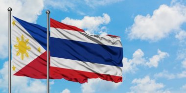 Filipinler ve Tayland bayrağı birlikte beyaz bulutlu mavi gökyüzüne karşı rüzgarsal sallayarak. Diplomasi kavramı, uluslararası ilişkiler.
