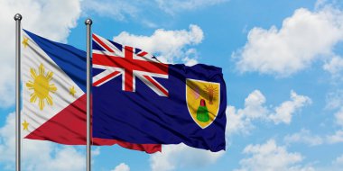 Filipinler ve Turks ve Caicos Adaları bayrağı birlikte beyaz bulutlu mavi gökyüzüne karşı rüzgarsal sallayarak. Diplomasi kavramı, uluslararası ilişkiler.