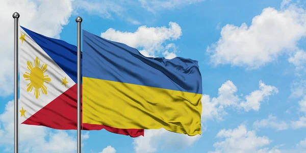 Филиппины и флаг Украины вместе машут ветром против белого облачного голубого неба. Концепция дипломатии, международные отношения . — стоковое фото