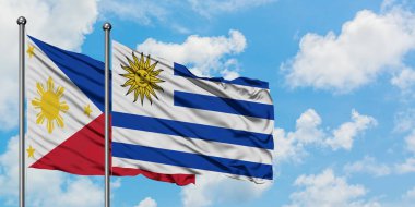 Filipinler ve Uruguay bayrağı birlikte beyaz bulutlu mavi gökyüzüne karşı rüzgarsal sallayarak. Diplomasi kavramı, uluslararası ilişkiler.