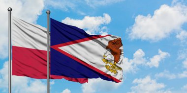 Polonya ve Amerikan Samoası bayrağı birlikte beyaz bulutlu mavi gökyüzüne karşı rüzgarda sallayarak. Diplomasi kavramı, uluslararası ilişkiler.