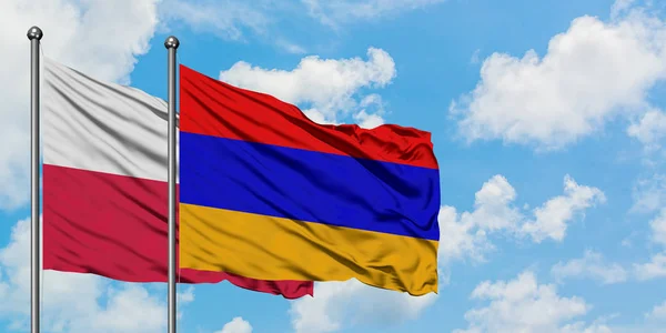 Bandera de Polonia y Armenia ondeando en el viento contra el cielo azul nublado blanco juntos. Concepto diplomático, relaciones internacionales . — Foto de Stock