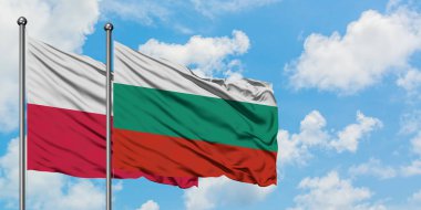 Polonya ve Bulgaristan bayrağı birlikte beyaz bulutlu mavi gökyüzüne karşı rüzgarda sallayarak. Diplomasi kavramı, uluslararası ilişkiler.