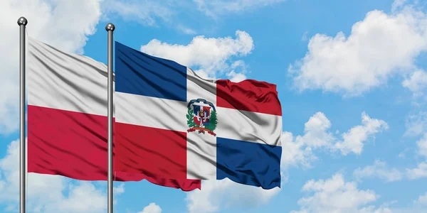 Bandera de Polonia y República Dominicana ondeando en el viento contra el cielo azul nublado blanco juntos. Concepto diplomático, relaciones internacionales . — Foto de Stock